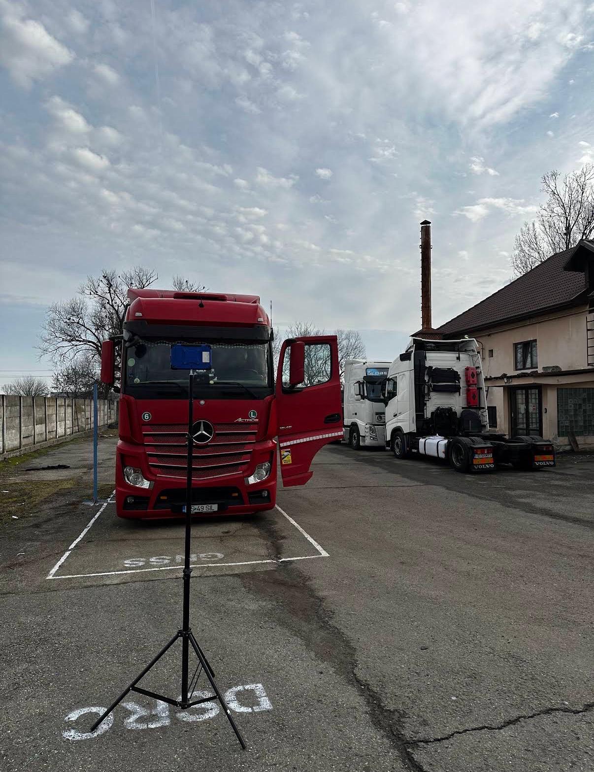 Mercedes-Benz Actros roșu poziționat pe platforma GNSS/DSRC a atelierului